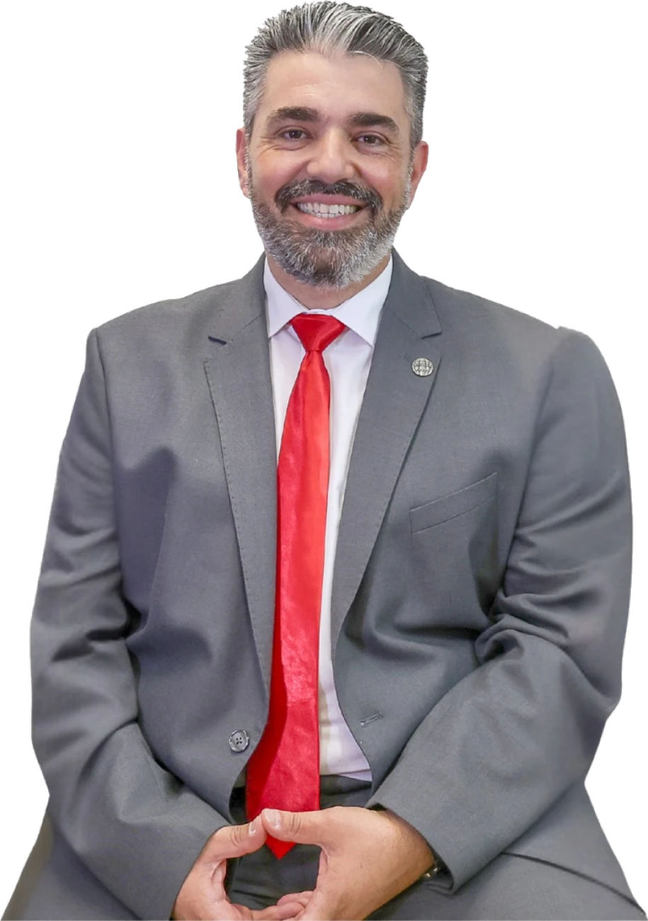 Fabiano Ferreira sentado, em fato cinzento e gravata vermelha.